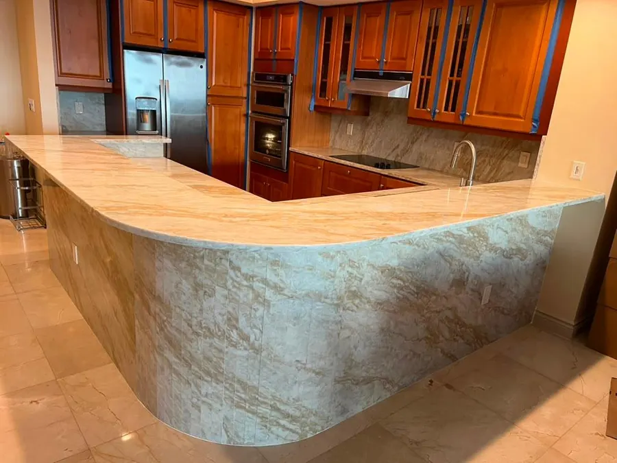 Bar-height kitchen island with a continuous curved quartzite face